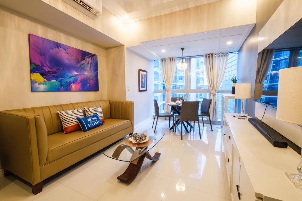 un soggiorno con divano e una sala da pranzo di Spacious 2BR Apartment in BGC with Workspace & Washer a Manila