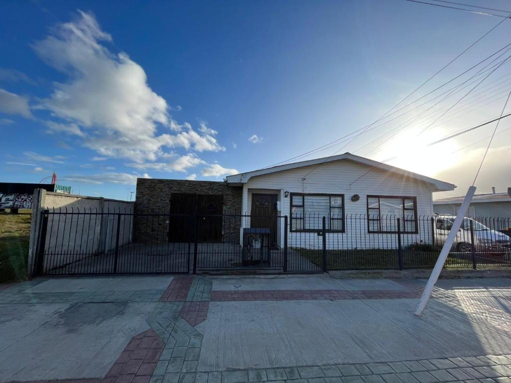 een wit huis met een hek ervoor bij Casa in Punta Arenas