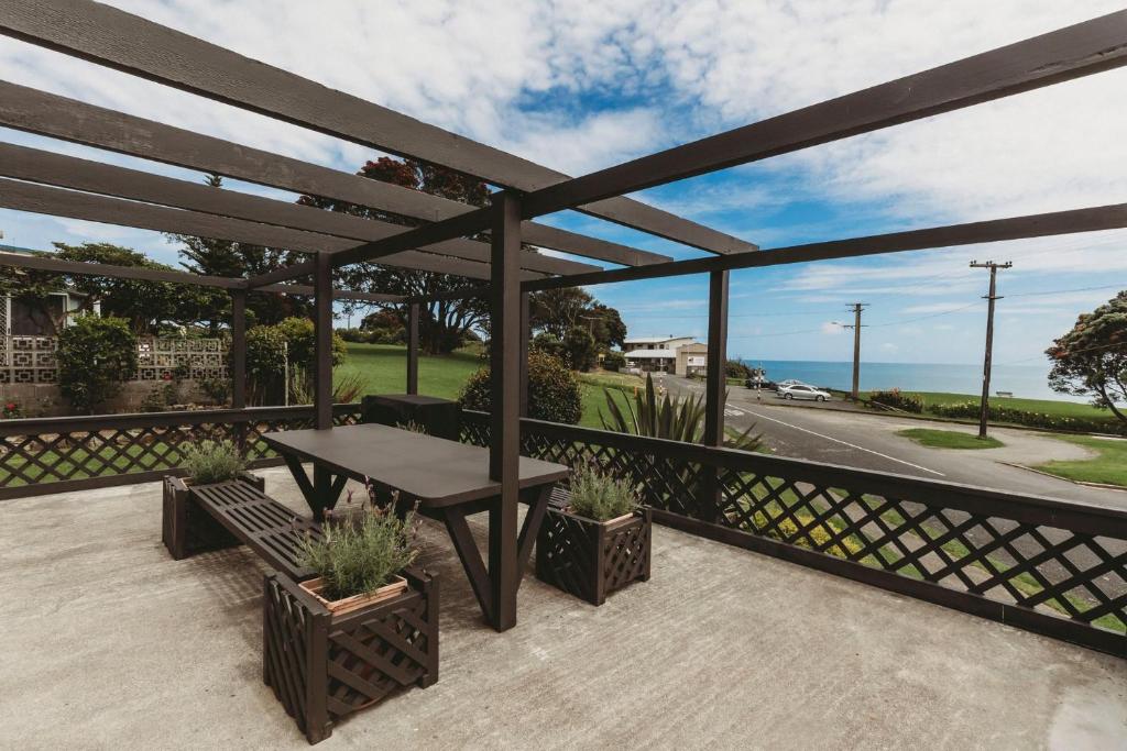 a patio with a table and a view of the ocean at Blue Haven On Belt Waterfront in New Plymouth