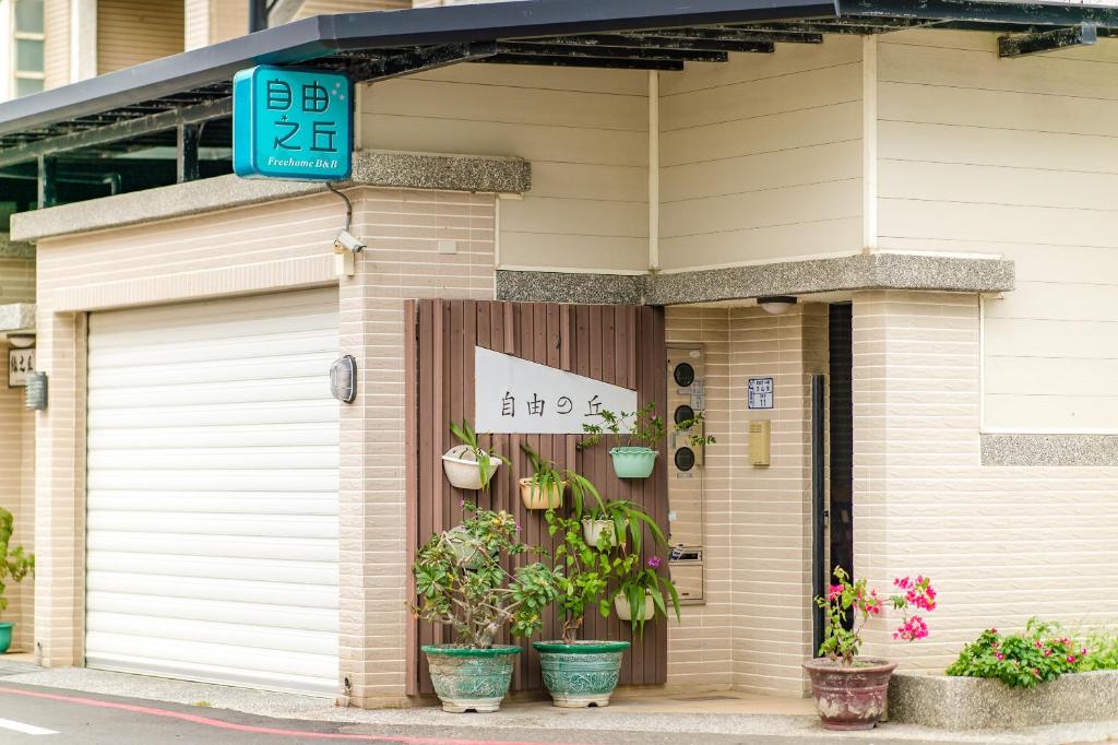 un edificio con un garaje con macetas. en 自由之丘民宿 l 寵物友善, en Taitung
