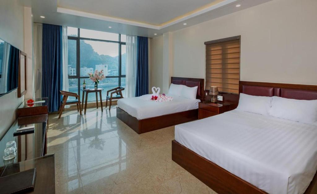 a hotel room with two beds and a television at Aroma Cat Ba Sea View Hotel in Cat Ba