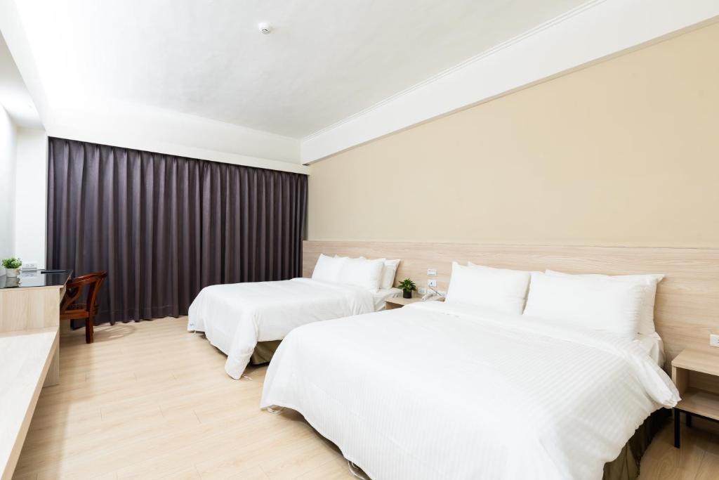 台中市にあるEtung Hotelのベッド2台とデスクが備わるホテルルームです。
