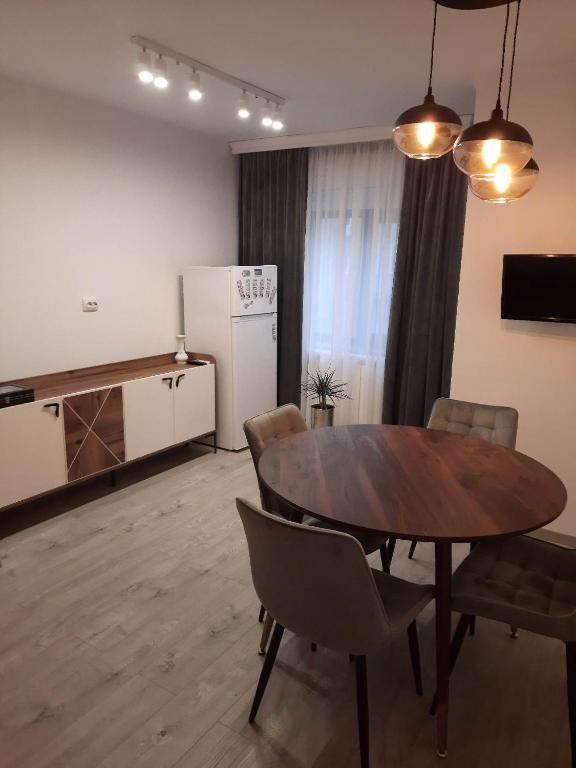 a room with a table and chairs and a refrigerator at RR Residence in Craiova