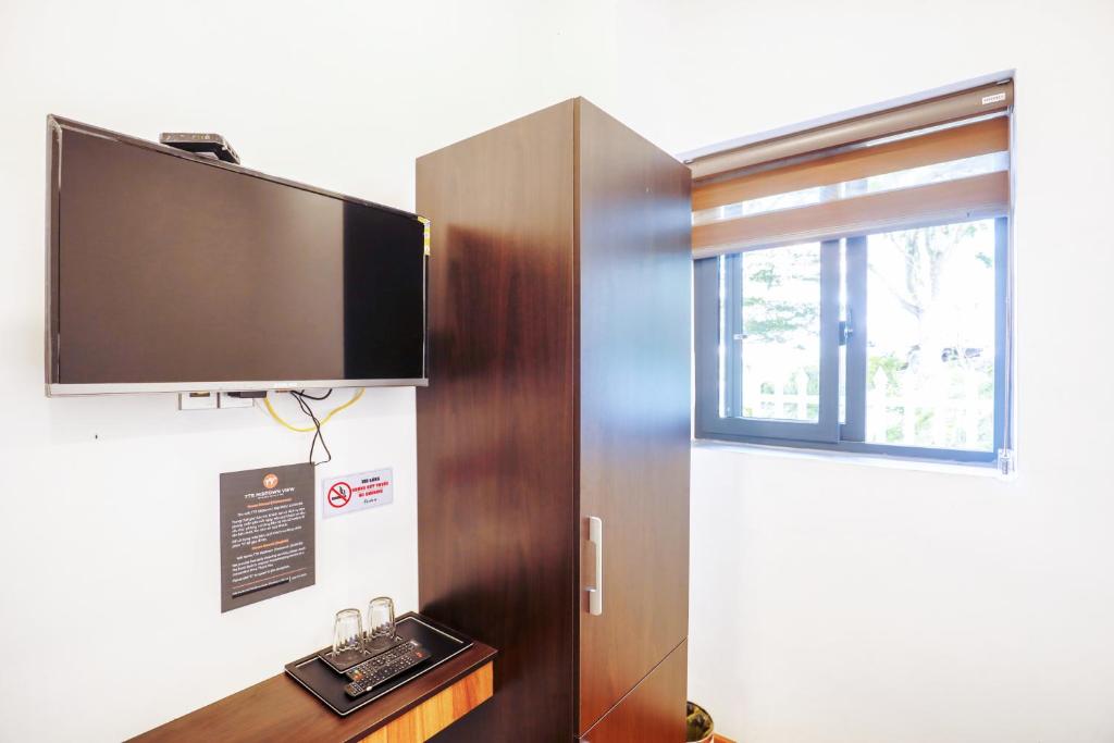a flat screen tv on a wall next to a door at TTR Midtown View Hotel in Da Lat