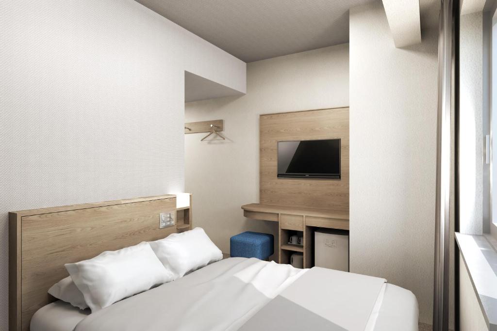 um quarto de hotel com uma cama e uma televisão em Sotetsu Fresa Inn Tokyo Kinshicho em Tóquio