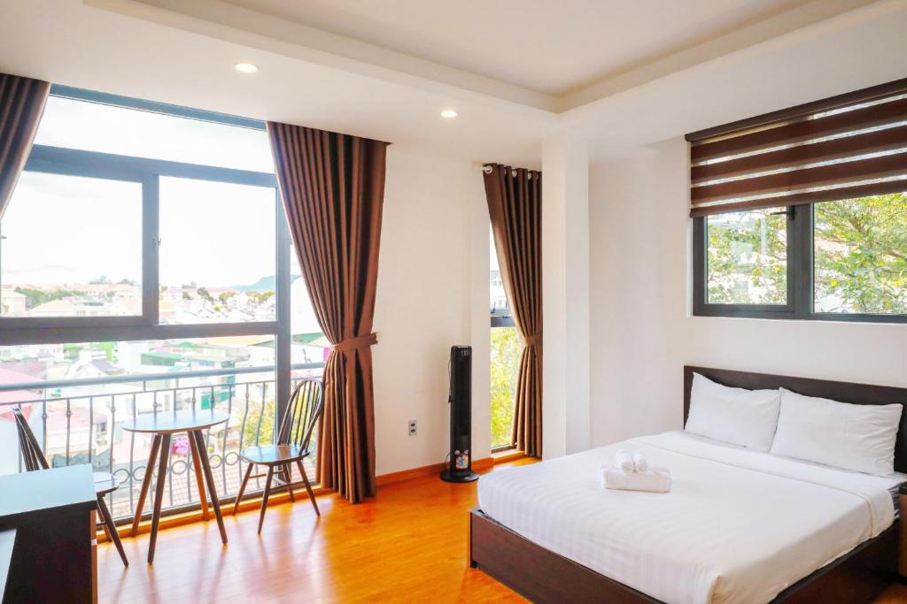 1 dormitorio con 1 cama y balcón en TTR Midtown View Hotel, en Da Lat
