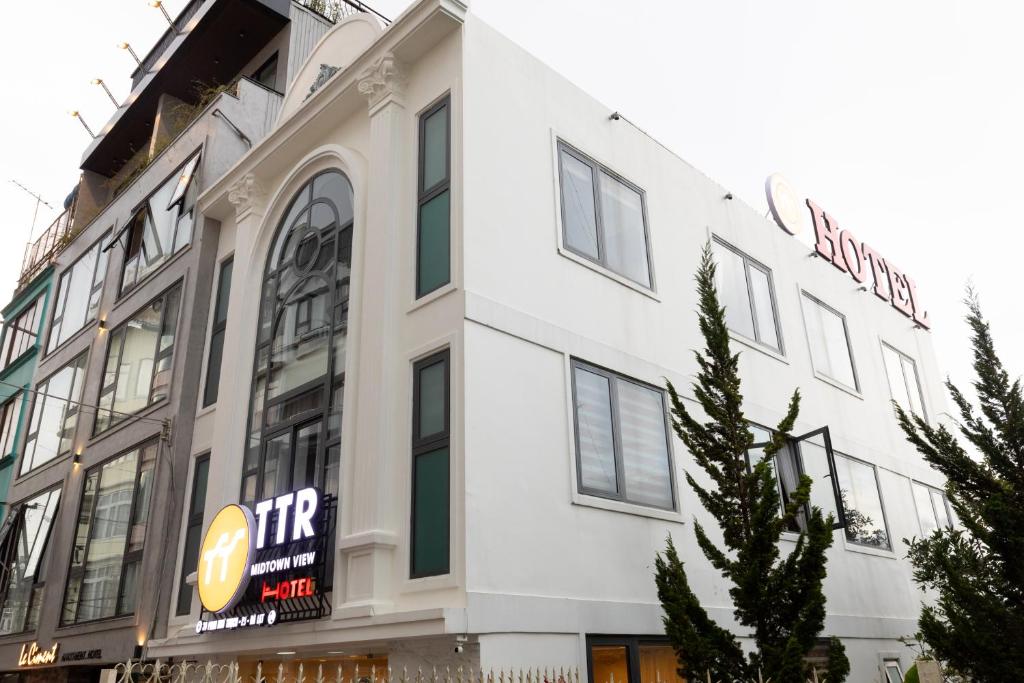 a white building with a sign on the side of it at TTR Midtown View Hotel in Da Lat