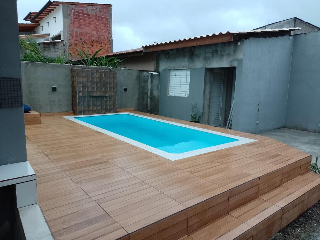 une terrasse avec une piscine au-dessus d'une maison dans l'établissement Casa com piscina perto da praia, à Caraguatatuba