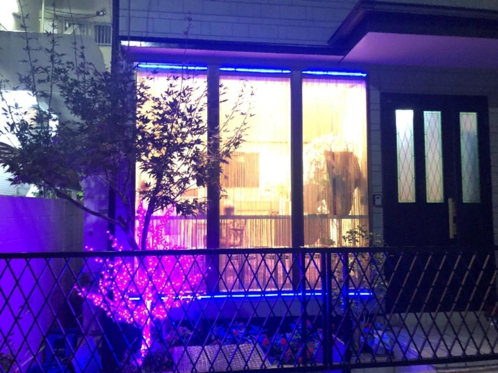東京にある冠京ホテルの紫と青の照明が窓に灯る家