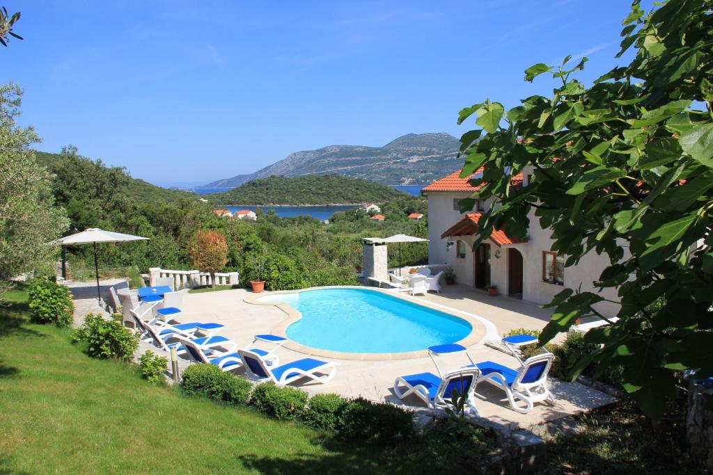 a swimming pool with lounge chairs and a pool at Apartments Grgic in Korčula
