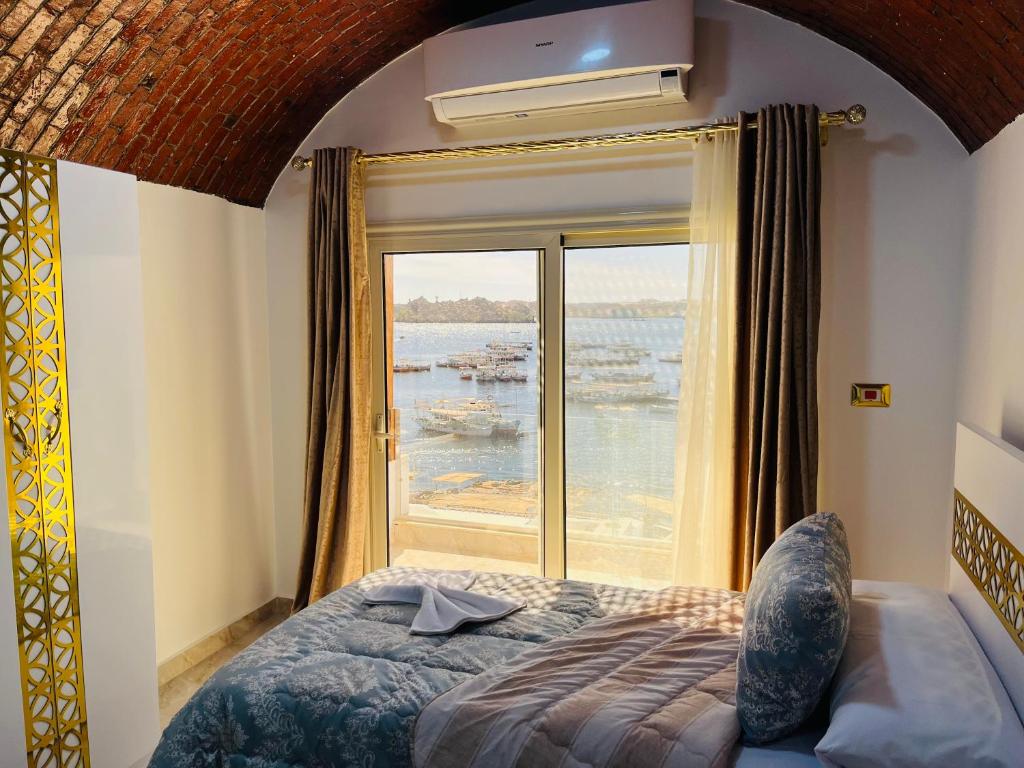 een slaapkamer met een bed en een groot raam bij Wanas Kato Guest House in Shellal