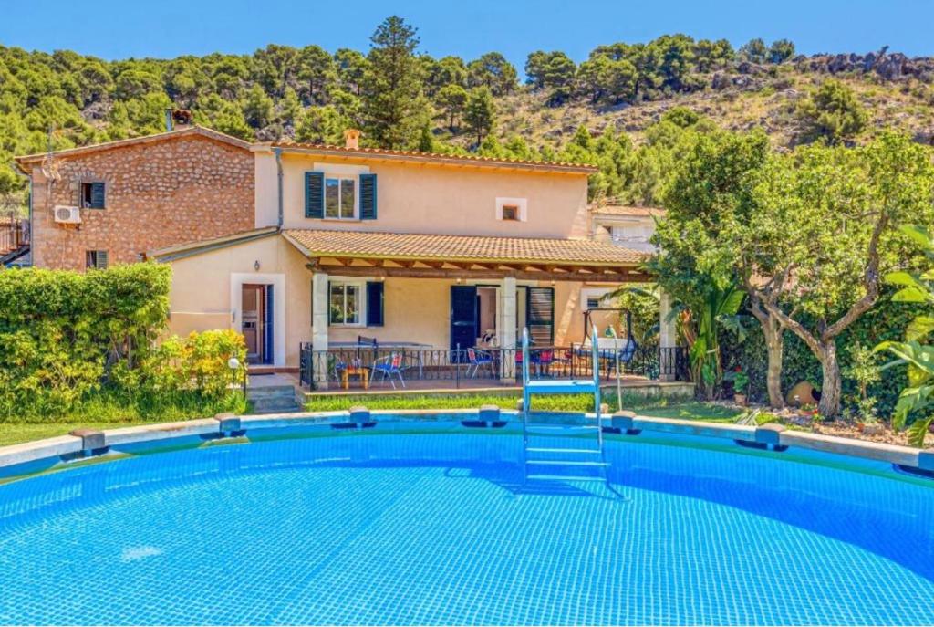 a villa with a swimming pool in front of a house at Can Freixa, fantástica villa con piscina in Sóller