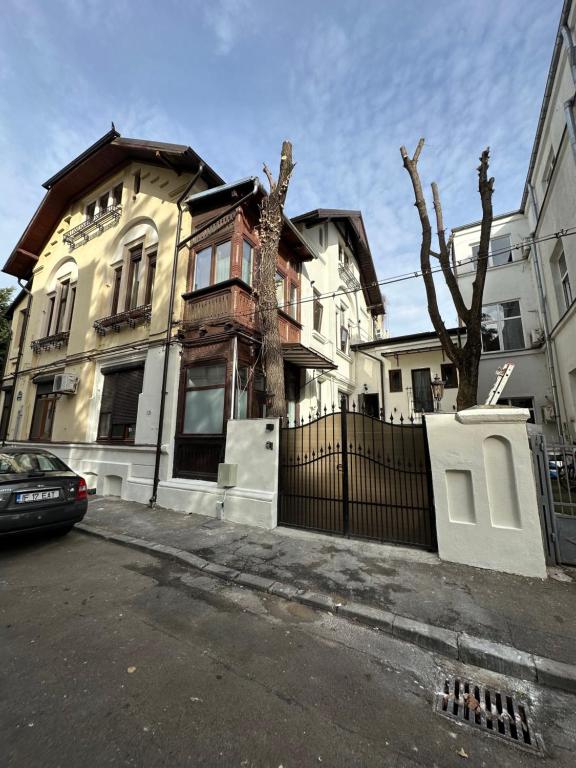 uma casa com uma cerca em frente em Cismigiu Apartments em Bucareste