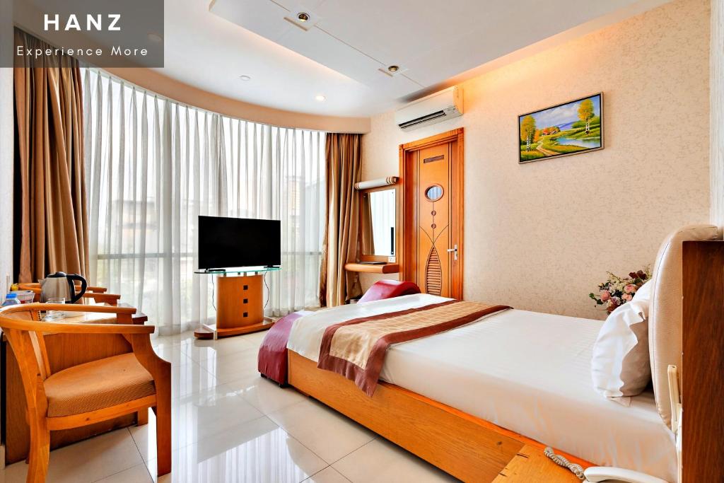 a hotel room with a bed and a television at HANZ Happy Hotel in Ho Chi Minh City
