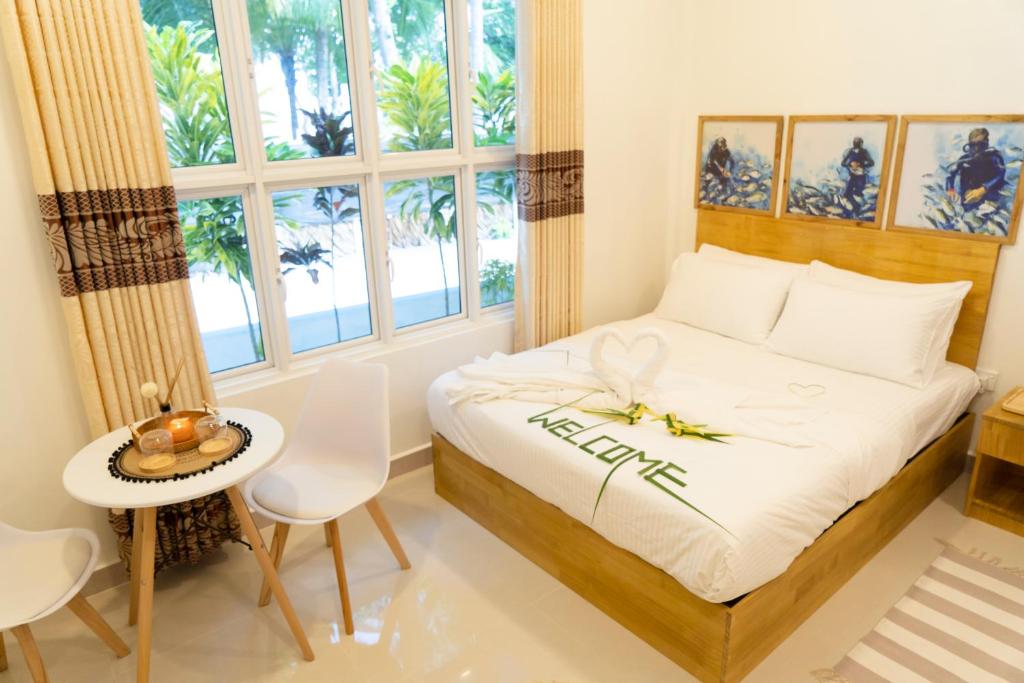 una camera con letto, tavolo e sedie di Palm Rest Maldives a Magoodhoo