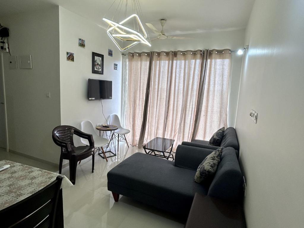 a living room with a couch and a table at Good Stay 2BHK Apartment - 702 in Dabolim