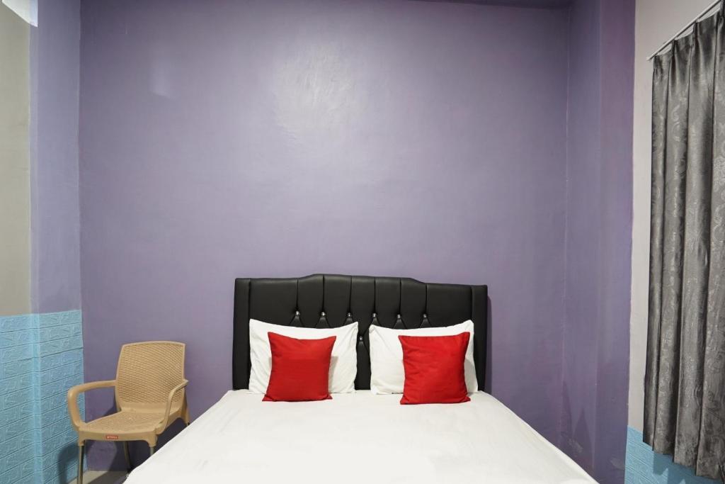 a bedroom with a bed with two red pillows at FA Homestay Syariah at Babat Lamongan Mitra RedDoorz in Lamongan