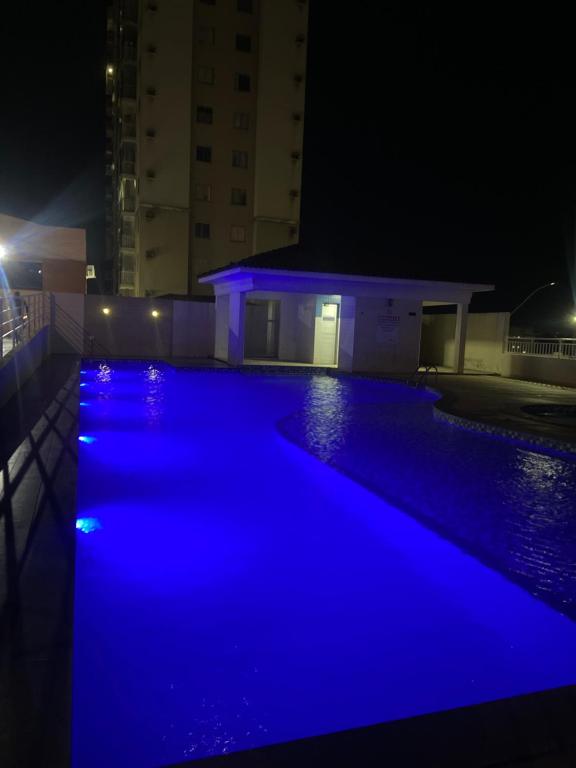 uma piscina iluminada de azul à noite em Ape aconchegante, perto da praia em Vila Velha