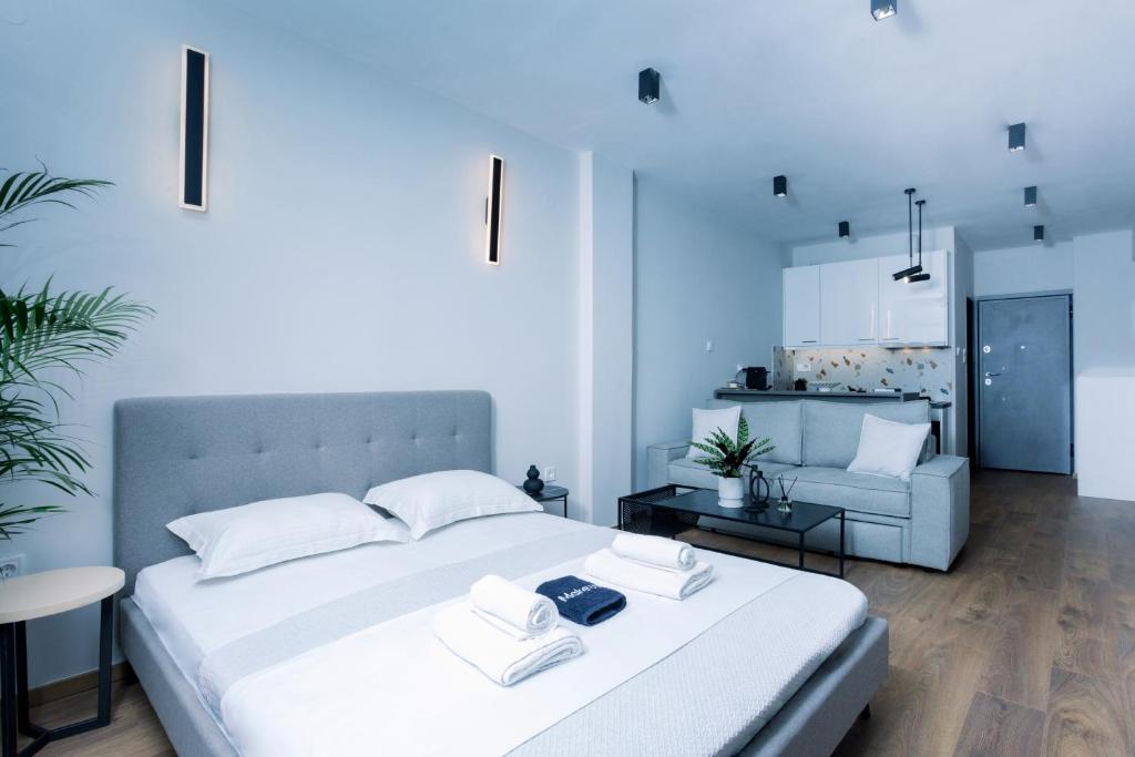a bedroom with a white bed and a living room at Luxury Downtown Apartment Α1 in Thessaloniki