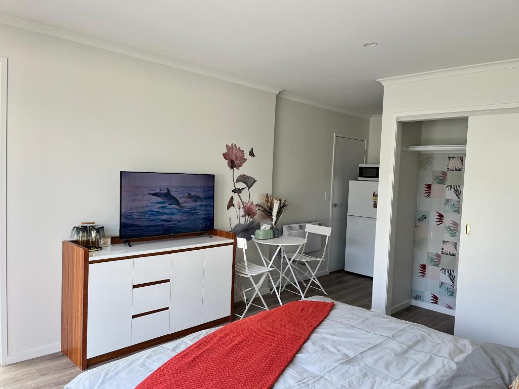 a bedroom with a tv on a white dresser at Lakeside cozy studio in Taupo