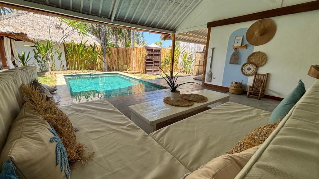 a living room with a couch and a swimming pool at villa Oceane in Gili Air