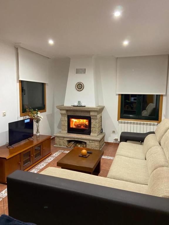 a living room with a couch and a fireplace at Preciosa casa en Bembrive in Vigo