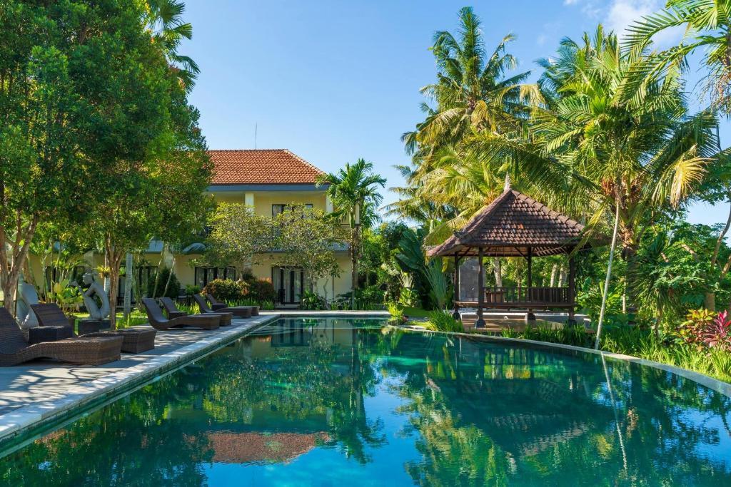 a swimming pool in front of a villa at Amatara Agung Raka in Ubud