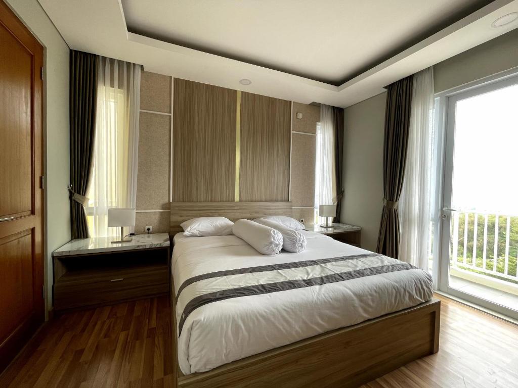a bedroom with a bed and a large window at Valle Verde Villas in Bandung