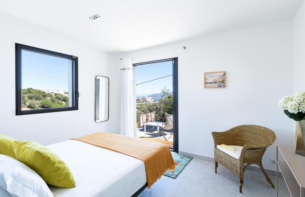 een slaapkamer met een bed, een raam en een stoel bij Villa Sottu in Calvi