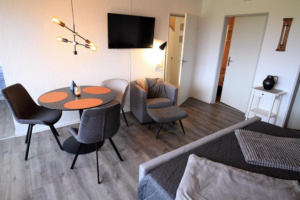 ein Wohnzimmer mit einem Tisch und Stühlen in der Unterkunft FeWo Friesenperle - Schillig in Horumersiel