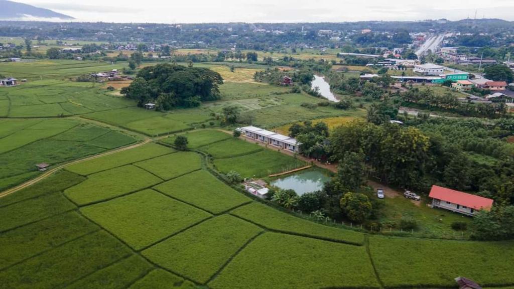 an aerial view of a field with a train and a lake at Blessing Pua in Ban Lao