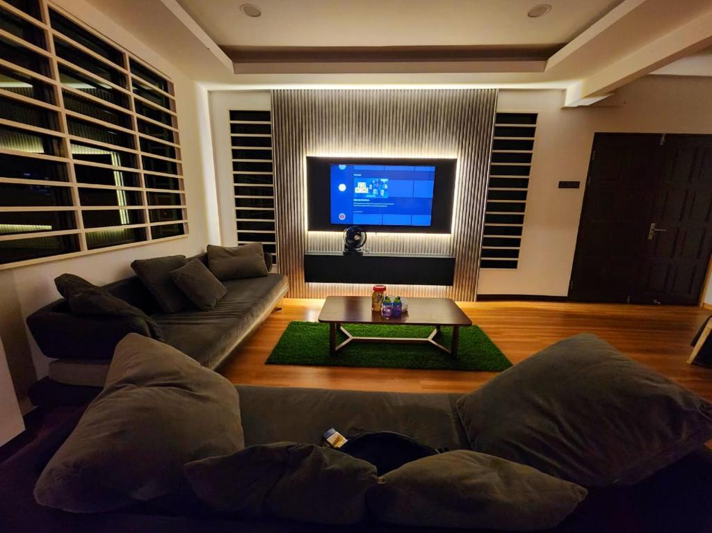 a living room with a couch and a tv at Kota Kinabalu family Home in Kota Kinabalu