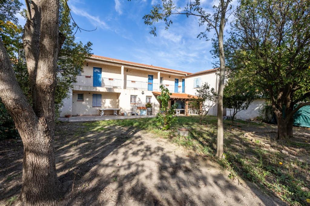 een exterieur van een huis met bomen bij Maison des Vignes - 7 chambres in Saint-André