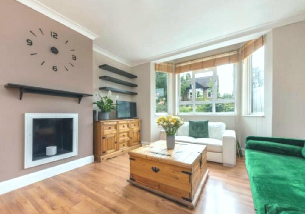 a living room with a couch and a clock on the wall at Walthamstow 1 bed in London