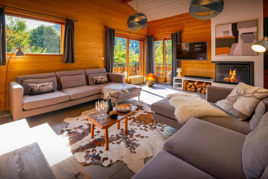 a living room with couches and a fireplace at Chalet Paravis - OVO Network in La Clusaz