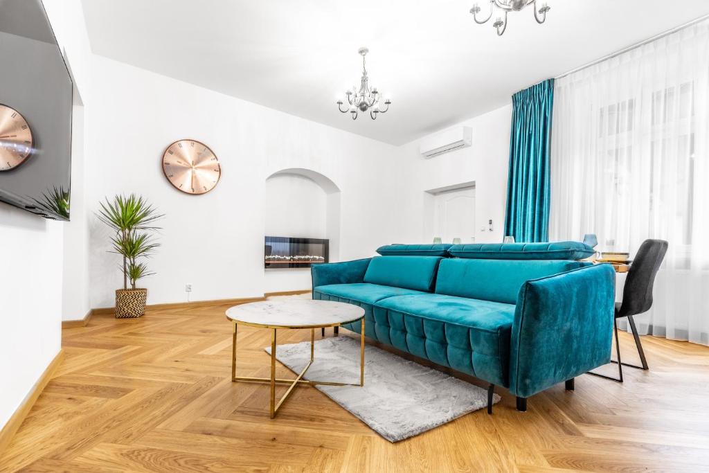 een woonkamer met een blauwe bank en een tafel bij Amazing Apartment in the Heart of City Center - DELUX in Lublin