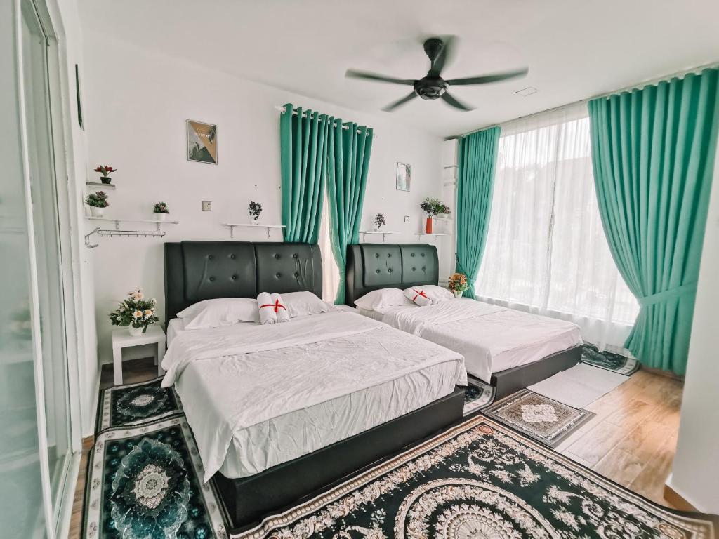 2 Betten in einem Schlafzimmer mit grünen Vorhängen in der Unterkunft Inap Idaman 5 With 2 Queen Bed In Kubang Kerian in Kota Bharu
