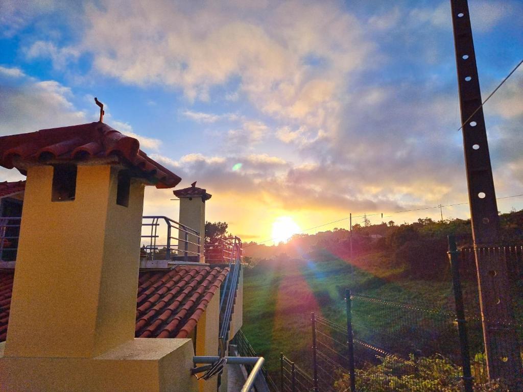 uma pessoa em pé no topo de um edifício ao pôr-do-sol em Casa en centro de Santana con vista al mar y la montaña em Santana