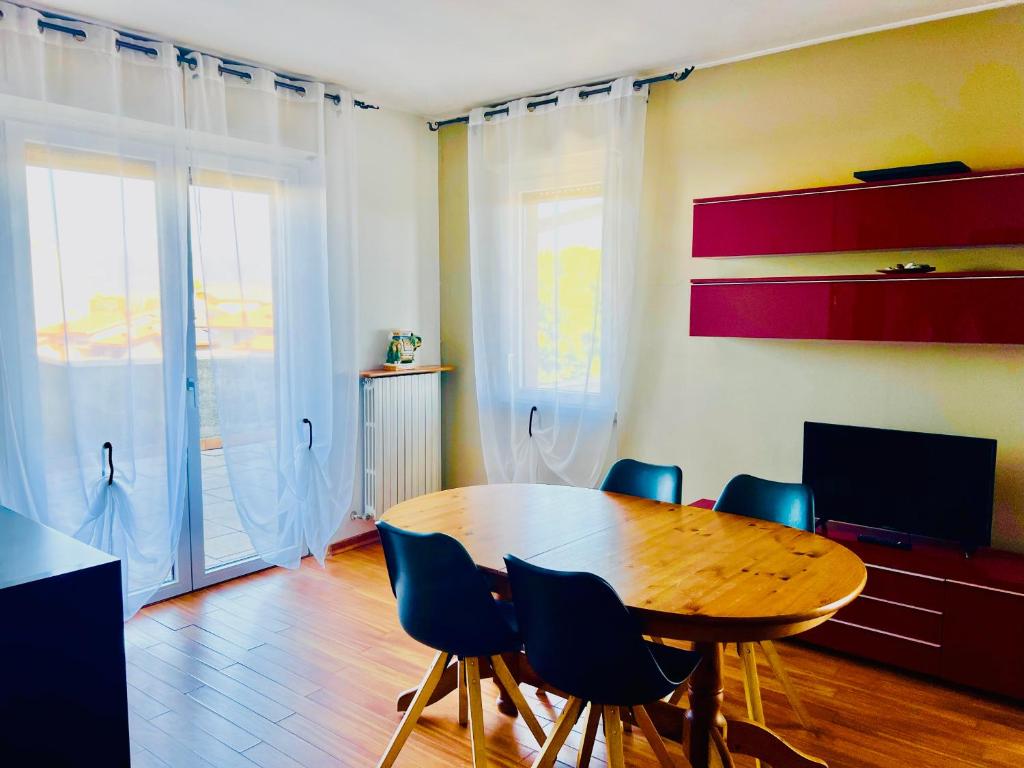 格拉索比奧的住宿－Orio Relax&Fly，一间带木桌和蓝色椅子的用餐室