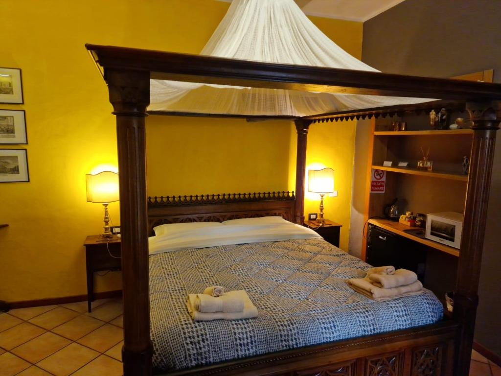 ein Schlafzimmer mit einem Himmelbett und Handtüchern darauf in der Unterkunft Corte Della Varesina in Mailand