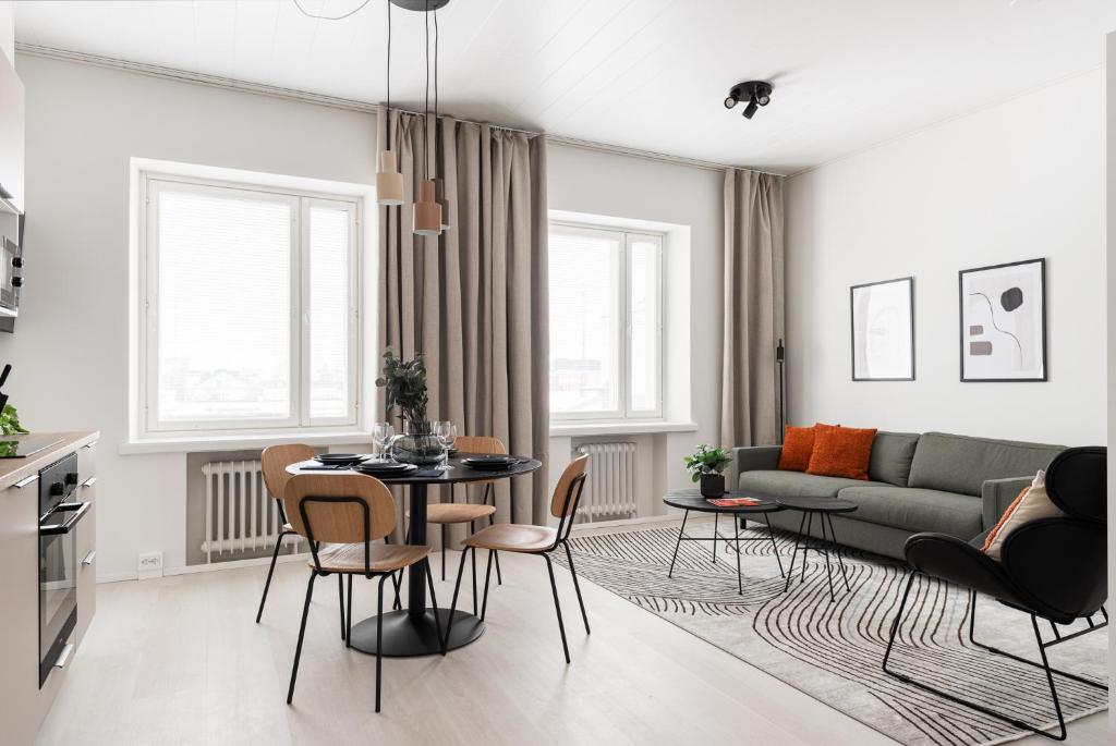 a living room with a table and chairs and a couch at Prime Apartments Pori Central in Pori