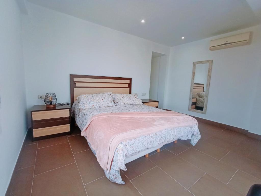 1 dormitorio con 1 cama grande y espejo en Caminos del Mediterráneo, en Castellón de la Plana