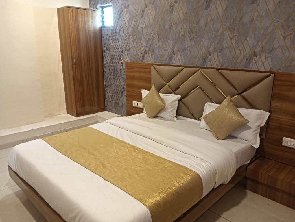 a bedroom with a large bed with a wooden headboard at Hotel Lake View AC room in Vadodara