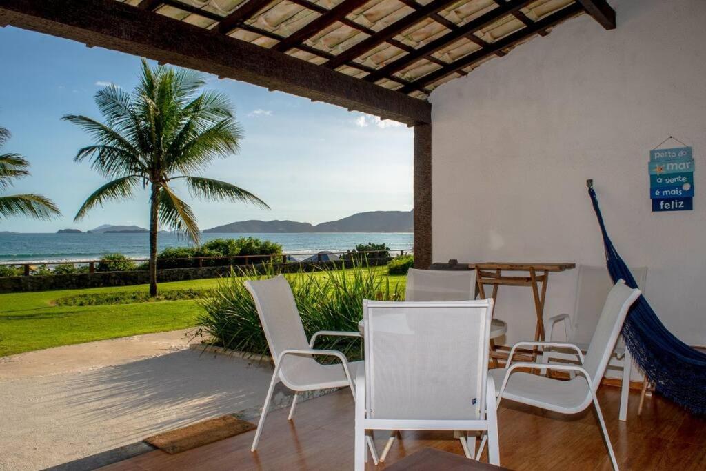 a patio with a table and chairs and the ocean at Casa Frente para o Mar em Búzios, Geribá Beach! in Búzios