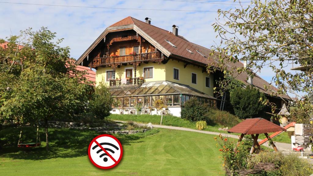 a house with a sign in front of a yard at stay & relax am Bio Archehof Zachhiesen in Seekirchen am Wallersee