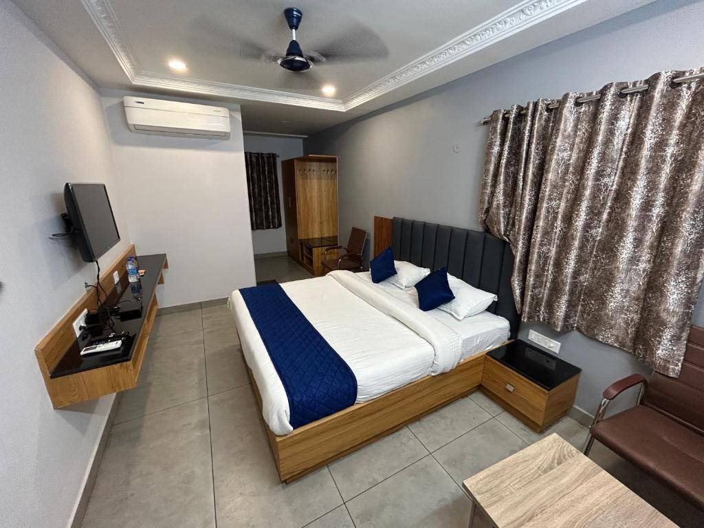 ein Schlafzimmer mit einem Bett und einem TV in der Unterkunft KKM Highlands in Kurnool