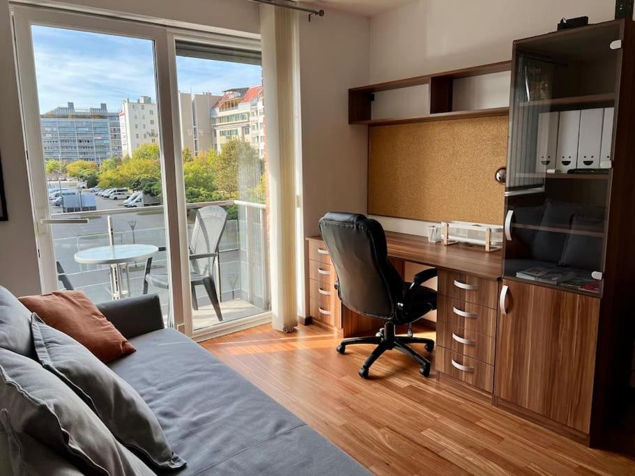 een woonkamer met een bureau met een stoel en een raam bij Dandár Studio Budapest in Boedapest