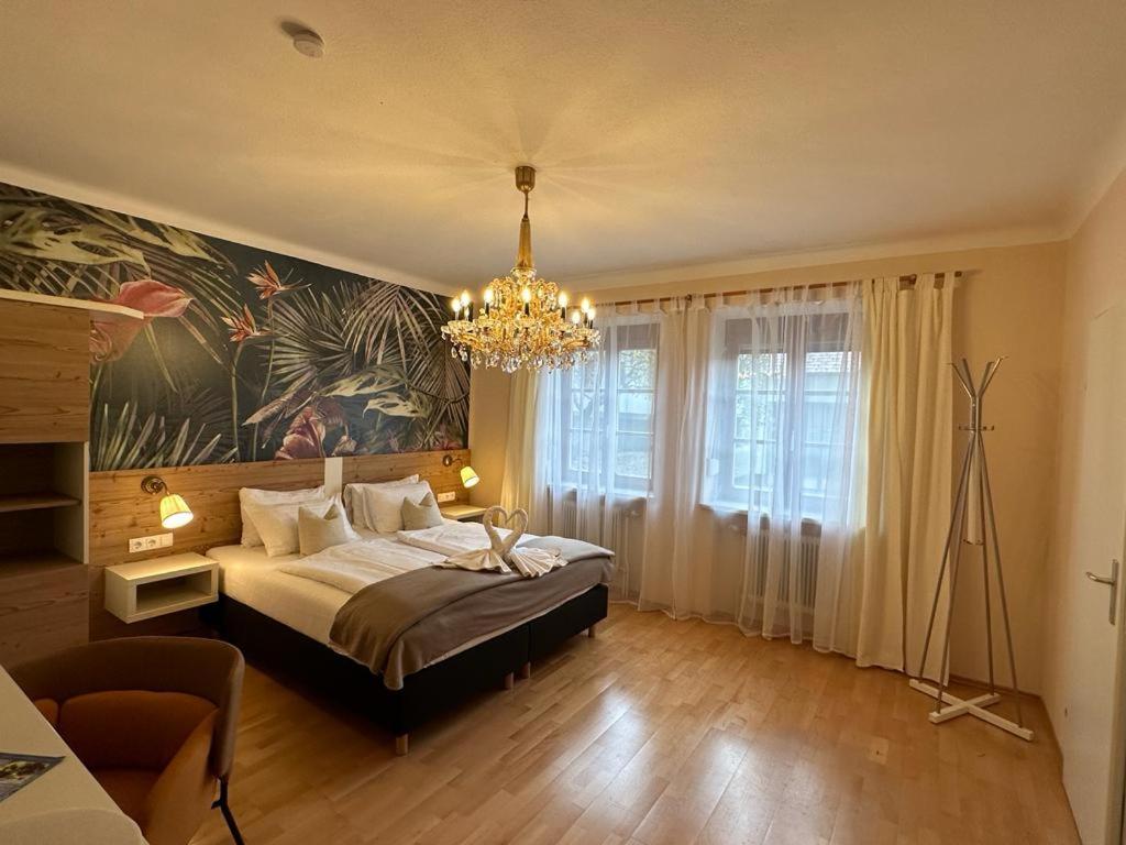 ein Schlafzimmer mit einem großen Bett und einem Kronleuchter in der Unterkunft Pension Amelie in Mörbisch am See