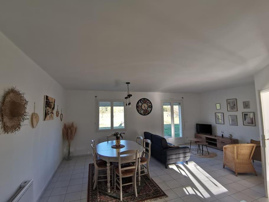 a dining room and living room with a table and chairs at La Maison du Bagas, 7pers in Vielmur-sur-Agout