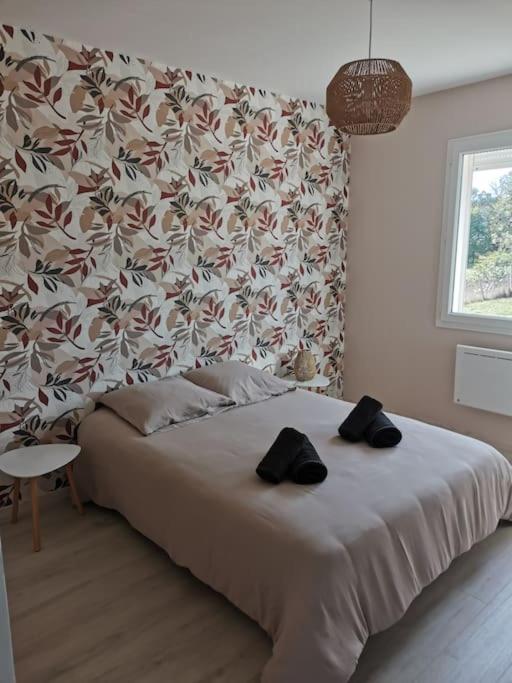 a bedroom with a bed with two black shoes on it at La Maison du Bagas, 7pers in Vielmur